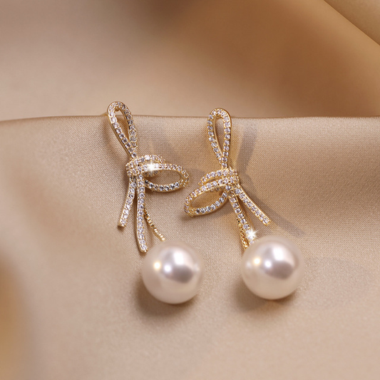 Pendientes de perlas con un lazo brillante en oro