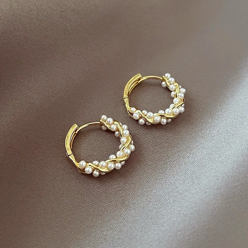 Aretes elegantes de perlas redondas con incrustaciones