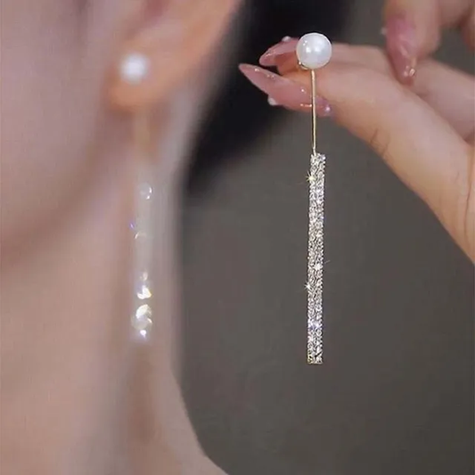 Pendientes elegantes y brillantes de perlas colgantes